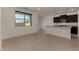 Open-concept living space with large windows and tile flooring, leading to the kitchen at 19924 W Rancho Dr, Litchfield Park, AZ 85340