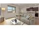 Bright living room featuring modern gray sofa, open floor plan and kitchen view at 19924 W Rancho Dr, Litchfield Park, AZ 85340