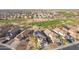 Aerial view of desert homes showcasing lush golf course with mature landscaping and solar panels at 22491 W Woodlands Ave, Buckeye, AZ 85326