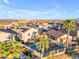 Desert home boasts a private pool, covered patio, mature landscaping with palm trees, and solar panels at 22491 W Woodlands Ave, Buckeye, AZ 85326