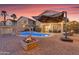 Inviting backyard oasis with a sparkling pool, fire pit, and covered patio, perfect for outdoor entertaining at 22491 W Woodlands Ave, Buckeye, AZ 85326