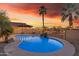 Inviting backyard pool with water feature, patio umbrella, and accent lighting at 22491 W Woodlands Ave, Buckeye, AZ 85326