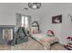 Charming bedroom featuring a rug, a large window, modern ceiling fan, and creative decor at 22491 W Woodlands Ave, Buckeye, AZ 85326
