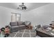 Bedroom features a gray sofa, patterned rug, and large window, providing a comfortable space with ample natural light at 22491 W Woodlands Ave, Buckeye, AZ 85326