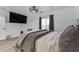 Bright bedroom featuring a large window, modern ceiling fan, and a mounted flatscreen television at 22491 W Woodlands Ave, Buckeye, AZ 85326