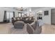 Open-concept living room featuring a large sectional, accent chair, and easy access to the kitchen at 22491 W Woodlands Ave, Buckeye, AZ 85326