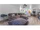 Open living area featuring a large sectional sofa, hardwood floors, and modern design, creating an inviting and stylish space at 22491 W Woodlands Ave, Buckeye, AZ 85326