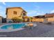 Gorgeous backyard pool with stone features, surrounded by a brick patio and lush landscaping, perfect for relaxation and entertaining at 22491 W Woodlands Ave, Buckeye, AZ 85326
