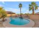 Inviting backyard pool featuring palm trees and a charming rock waterfall feature at 22491 W Woodlands Ave, Buckeye, AZ 85326