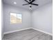 Bright bedroom featuring hard wood flooring, a ceiling fan, and a scenic view from the window at 27145 N 147Th Ave, Surprise, AZ 85387