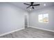 Bright bedroom featuring hardwood flooring, a ceiling fan, closet space, and a window with a view at 27145 N 147Th Ave, Surprise, AZ 85387