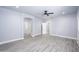 Spacious bedroom featuring modern gray flooring, ceiling fan, and neutral walls at 27145 N 147Th Ave, Surprise, AZ 85387
