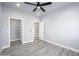 Well-lit bedroom featuring hardwood flooring, a ceiling fan, and a walk-in closet at 27145 N 147Th Ave, Surprise, AZ 85387