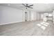 Expansive living room showcases wood-look floors, neutral tones, ceiling fan, and open floor plan to kitchen at 27145 N 147Th Ave, Surprise, AZ 85387