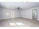 Bright living room with wood-look floors, ceiling fan, and access to backyard via glass door at 27145 N 147Th Ave, Surprise, AZ 85387