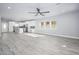 Open floor plan featuring wood-look floors, ceiling fan, neutral tones, and a kitchen with white cabinets at 27145 N 147Th Ave, Surprise, AZ 85387