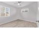 Bright bedroom with two windows, neutral walls, ceiling fan, and vinyl flooring at 3035 W Pierce St, Phoenix, AZ 85009