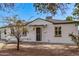 Single-story home with white brick, black trim, desert landscaping, and covered porch at 3035 W Pierce St, Phoenix, AZ 85009