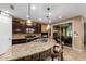 Modern kitchen featuring granite countertops, dark cabinetry, stainless steel appliances, and a breakfast bar at 3103 S Dakota Pl, Chandler, AZ 85248