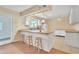 Kitchen with white cabinets, butcher block counters, stools at the island, and wood-look floors at 3349 E Carmel Ave, Mesa, AZ 85204