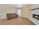 Inviting living room with a brick fireplace, wood mantle, and a comfortable leather sofa at 3349 E Carmel Ave, Mesa, AZ 85204