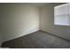 A well-lit bedroom with plush carpeting and a window offering natural light at 36638 W Santa Clara Ave, Maricopa, AZ 85138