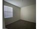 A well-lit bedroom with plush carpeting and a window offering natural light at 36638 W Santa Clara Ave, Maricopa, AZ 85138