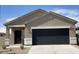 Close up of a charming single-story home featuring a two-car garage and desert landscaping at 36638 W Santa Clara Ave, Maricopa, AZ 85138