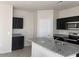 Kitchen featuring dark cabinets, granite countertops, and stainless steel appliances at 36638 W Santa Clara Ave, Maricopa, AZ 85138