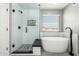 Bright bathroom features a glass shower with mosaic tile and a modern soaking tub at 3730 E Diamond Ct, Gilbert, AZ 85297