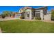 Inviting front yard of a two-story home featuring lush green grass, mature trees, and a three-car garage at 3730 E Diamond Ct, Gilbert, AZ 85297