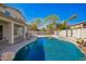 Relax in this backyard oasis featuring a stunning pool, rock waterfall feature, and covered patio for outdoor living at 3730 E Diamond Ct, Gilbert, AZ 85297