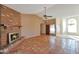 Bright living room with a brick fireplace, tile flooring, and a ceiling fan for added comfort at 4080 W Orchid Ln, Chandler, AZ 85226