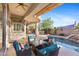 Covered patio area featuring wicker furniture and views of the pool and desert landscaping at 42047 N Moss Springs Rd, Anthem, AZ 85086