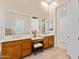 A bathroom with dual vanities, wood cabinetry, and mirrors, offering a functional and elegant space for personal care at 42047 N Moss Springs Rd, Anthem, AZ 85086