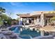 Backyard pool with rock features and covered patio for entertaining at 42047 N Moss Springs Rd, Anthem, AZ 85086