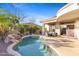 Backyard pool with covered patio, desert landscaping, and lush greenery at 42047 N Moss Springs Rd, Anthem, AZ 85086