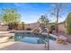 Private pool area with mature trees, natural rock accents, and a waterfall feature offers a serene backyard setting at 42047 N Moss Springs Rd, Anthem, AZ 85086