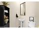 Cozy powder room with pedestal sink and decorative accents at 42047 N Moss Springs Rd, Anthem, AZ 85086
