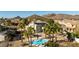 A lovely backyard featuring a pool with rock features surrounded by palm trees, ideal for relaxing and enjoying the outdoors at 4803 W Buckskin Trl, Phoenix, AZ 85083