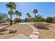 A backyard with a pool, palm trees, desert landscaping, and stepping stones at 4803 W Buckskin Trl, Phoenix, AZ 85083
