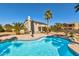 A backyard with a beautiful pool, patio, and desert landscaping with mature palm trees at 4803 W Buckskin Trl, Phoenix, AZ 85083