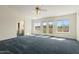 Spacious living room with carpet, ceiling fan and several bright windows at 4803 W Buckskin Trl, Phoenix, AZ 85083