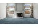 Open-concept living room with traditional fireplace and abundant natural light from surrounding windows at 4803 W Buckskin Trl, Phoenix, AZ 85083