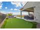 A putting green and outdoor kitchen with a large covered patio create an ideal entertainment space at 5189 N 206Th Dr, Buckeye, AZ 85396