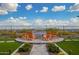 Outdoor fireplace with orange Adirondack chairs set on a circular paved patio and green grass at 5189 N 206Th Dr, Buckeye, AZ 85396