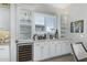 Bar area with wine cooler, custom cabinets, granite countertops, glass storage and decor at 5189 N 206Th Dr, Buckeye, AZ 85396