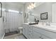 Well-lit bathroom with dual sinks, framed mirror and shower behind a decorative curtain at 5189 N 206Th Dr, Buckeye, AZ 85396