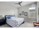Comfortable bedroom featuring a ceiling fan, bedside table, and patterned bedding at 5189 N 206Th Dr, Buckeye, AZ 85396