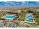 Aerial image of community pools surrounded by lush greenery and a clubhouse at 5189 N 206Th Dr, Buckeye, AZ 85396